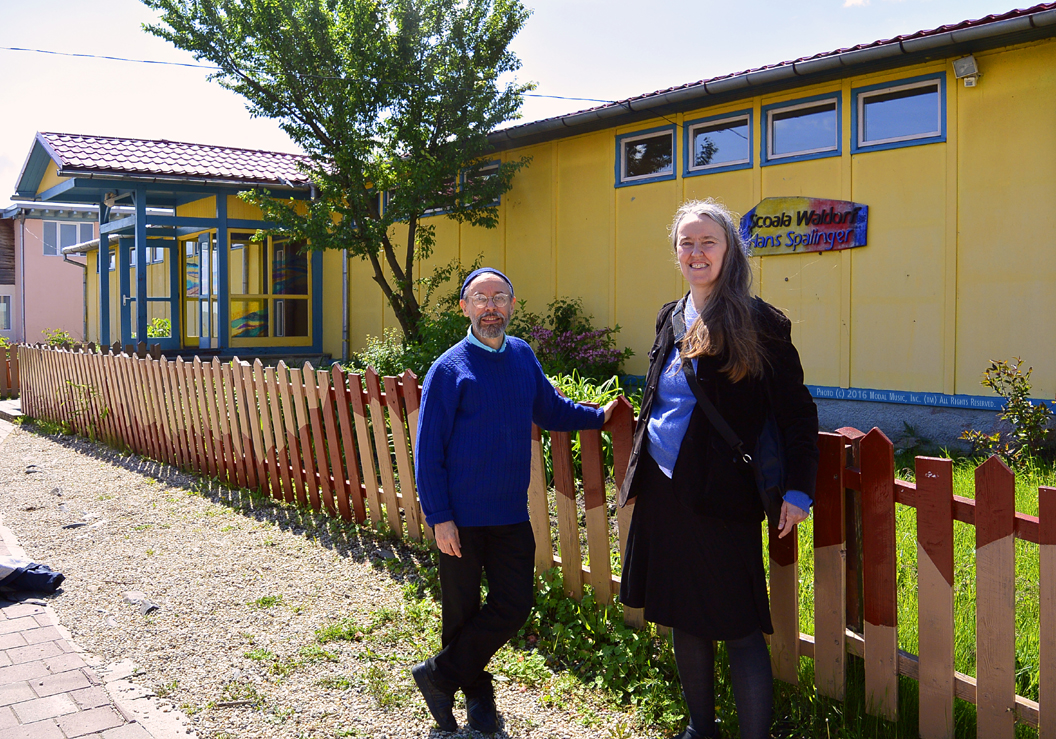 Image of Terran and Jutta in front of the Scoala Waldorf Hans Spalinger in Roşia, Romania